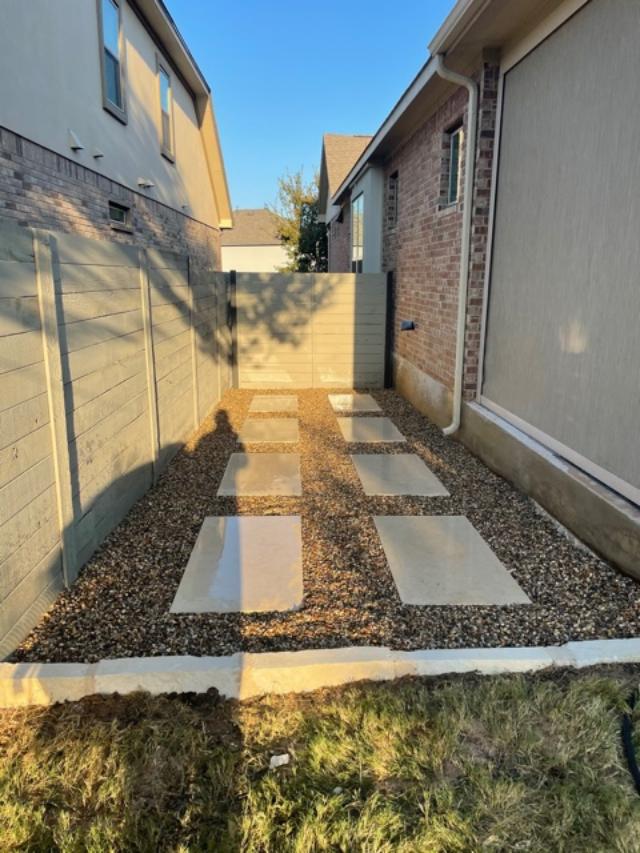 Narrow side yard with stone pavers pathway