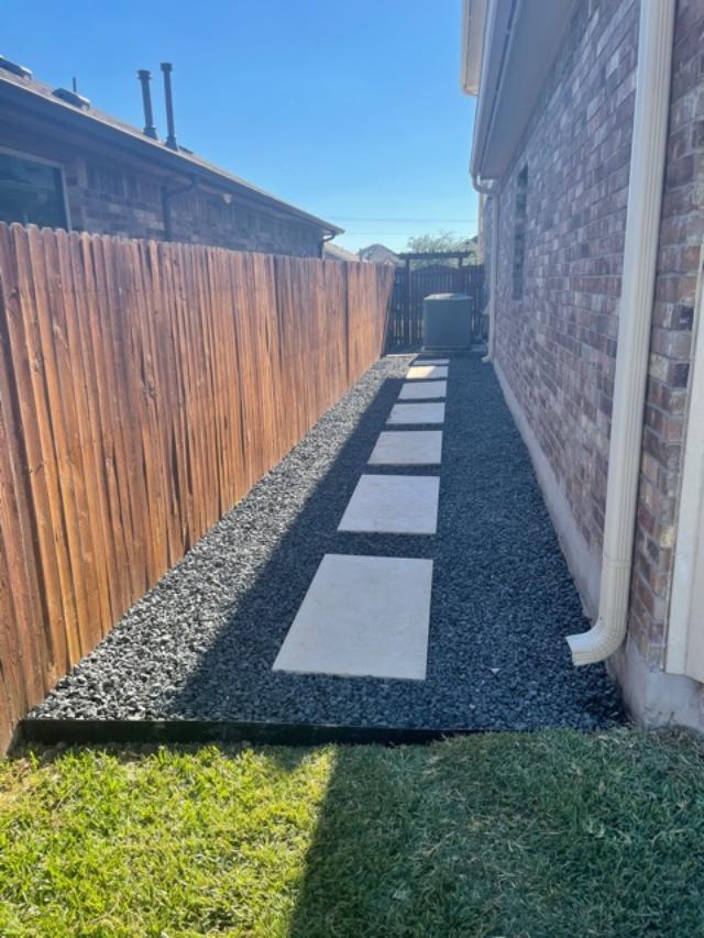 Side yard with stone pavers and wooden fence